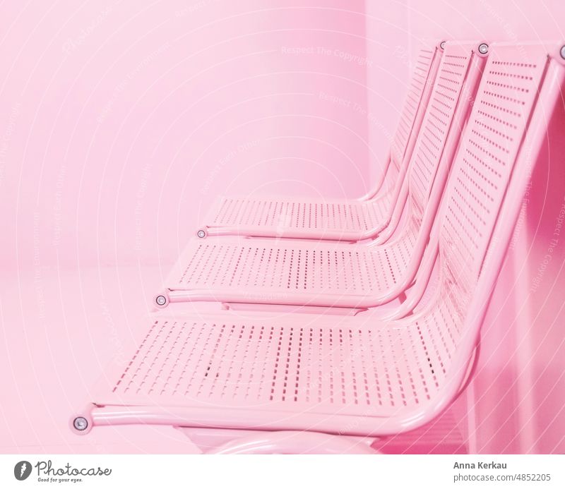 Pink row of chairs in front of a pink wall Row of chairs three Waiting room waiting area seated Unicoloured tranquil setting Seating Scene Interior shot