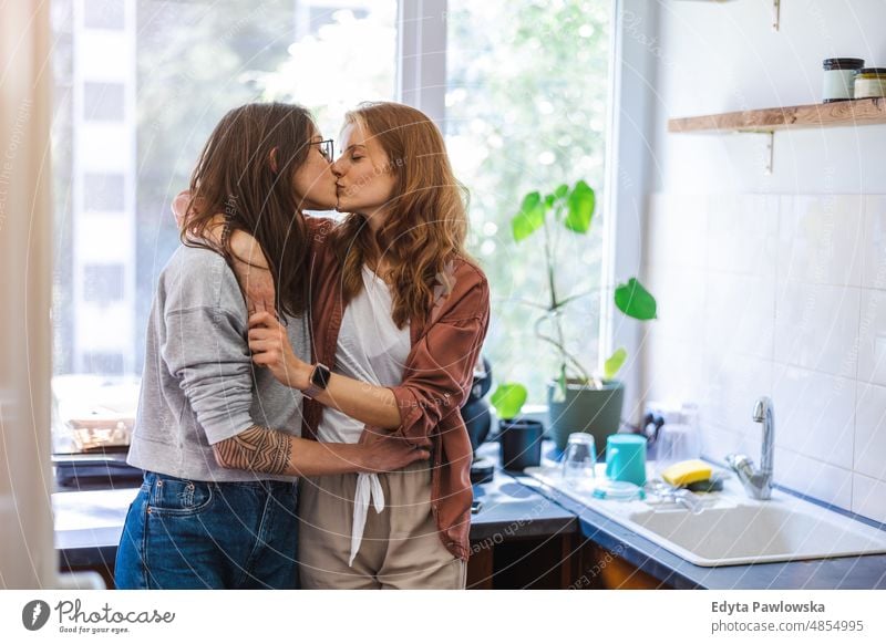 Lesbian couple kissing in their home same sex couple adult apartment attractive beautiful bonding dating couple enjoyment family female gay couple gay women