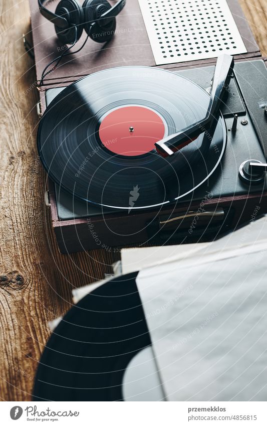 Listening to music from vinyl record. Playing music from analog disk on turntable player. Enjoying music from old collection. Relaxing at home. Retro and vintage