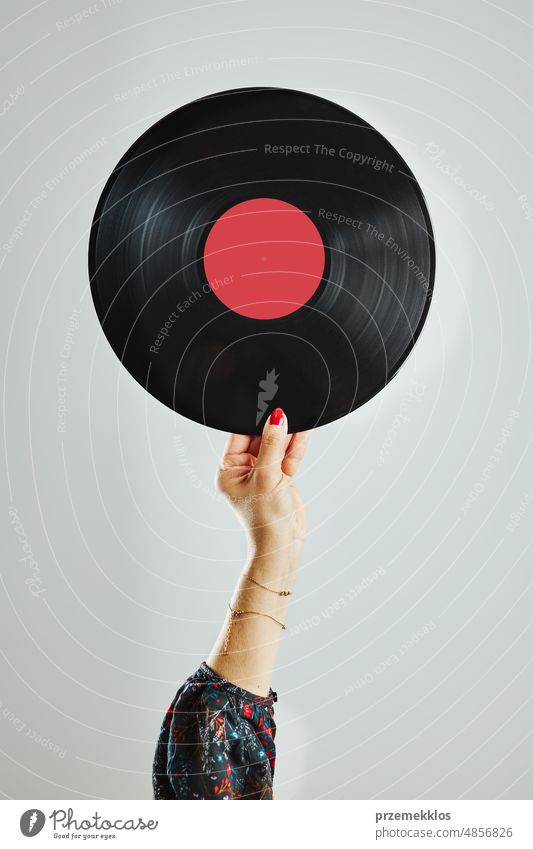 Woman holding vinyl record. Music passion. Listening to music from analog record. Playing music from analog disk. Enjoying music from old collection. Retro and vintage. Stereo audio. Analog sound