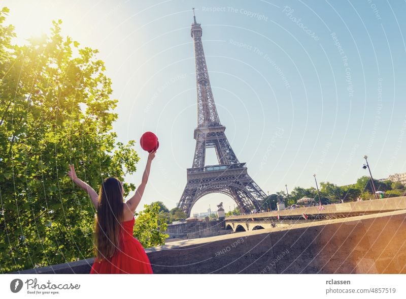 Young woman with red cap enjoying the great view on the Eiffel tower in Paris eiffel landmark france skyline europe sun flare summer seine adult caucasian