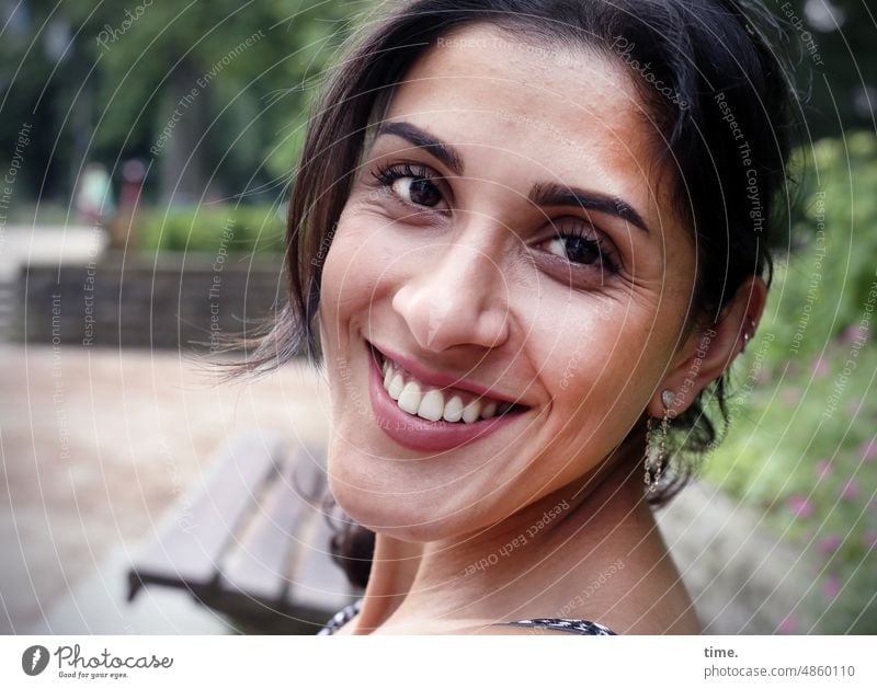 smiling woman in park Feminine Park bench Trust Looking Dark-haired Long-haired Jewellery fortunate contented cheerful Smiling feminine portrait