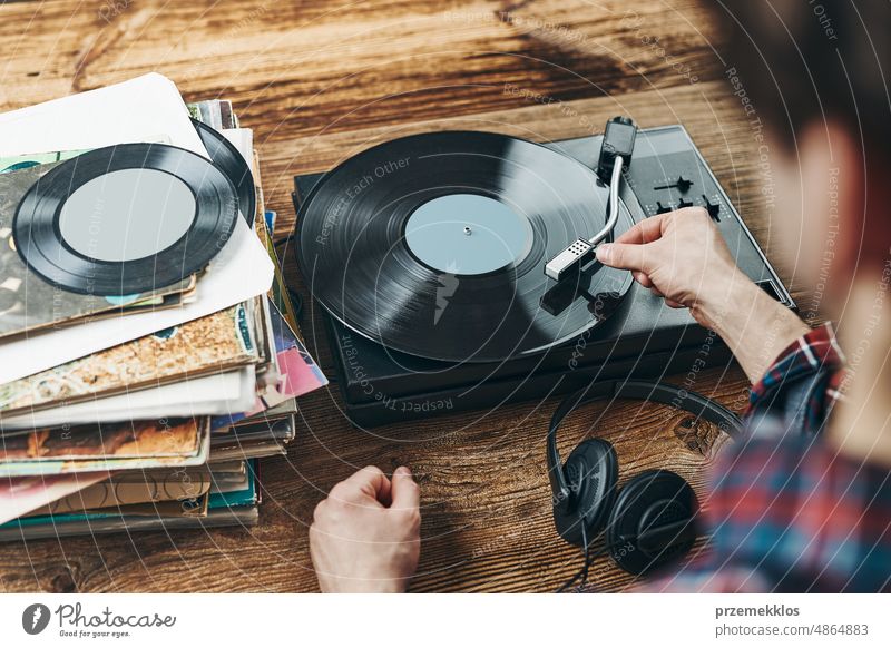 Man listening to music from vinyl record. Playing music from analog disk on turntable player. Enjoying music from old collection. Retro and vintage album retro