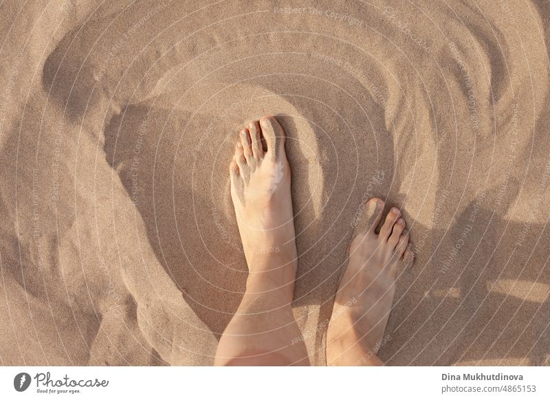Feet on sand. Barefoot woman walking on the sandy beach. Closeup of feet on soft texture of sand. Vacation and traveling. natural healthy medical sea outdoor
