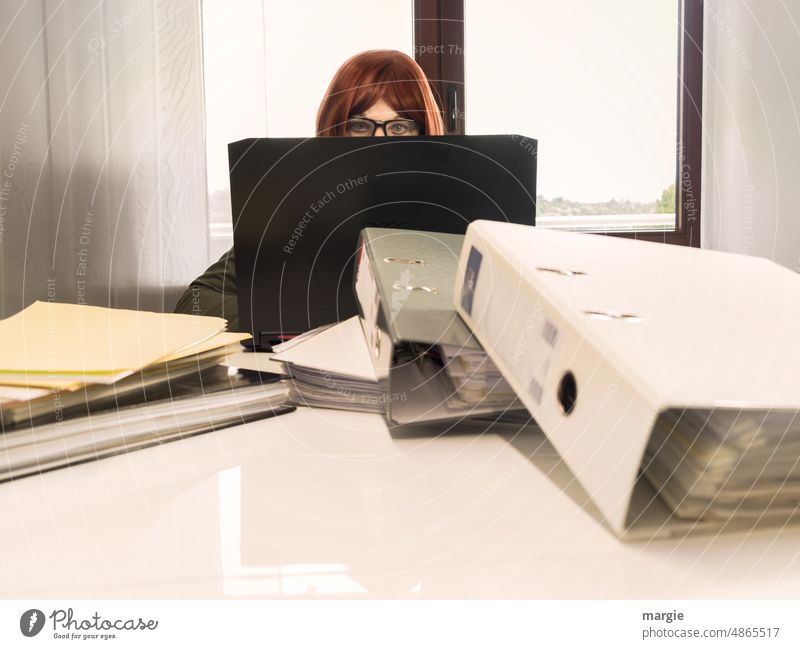 A woman with glasses sits at the notebook, laptop, files are stacked in front of her, work up to her ears! Office Office work Woman Business Workplace