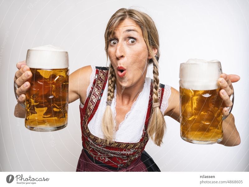 sexy traditional Oktoberfest visitor wearing a traditional Bavarian dress and holding big beer mugs at autumn in germany oktoberfest girl drink woman