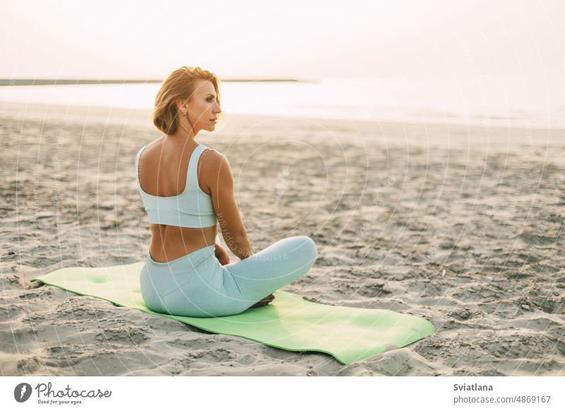 Free Photo  Young slim beautiful attractive woman relaxing on yoga mat in  the morning on sunrise by sea, healthy lifestyle, fitness sport