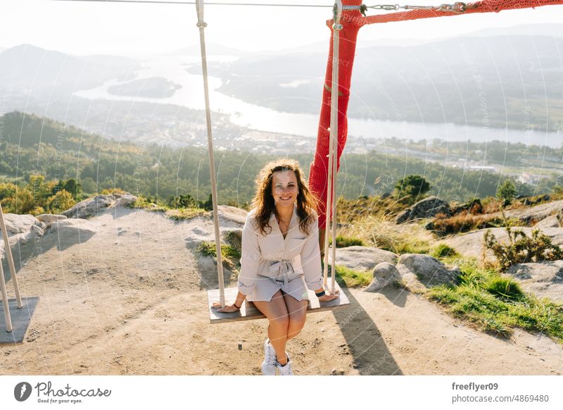 Young woman on a swing against a beautiful landscape portrait young caucasian nature copy space viewpoint galicia spain lifestyle vacation people travel summer
