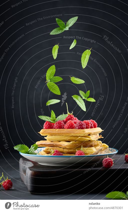 Stack of baked Belgian waffles with ripe red raspberry mint wafer wooden bakery belgian belgium levitation fall breakfast brown crispy delicious deliciously