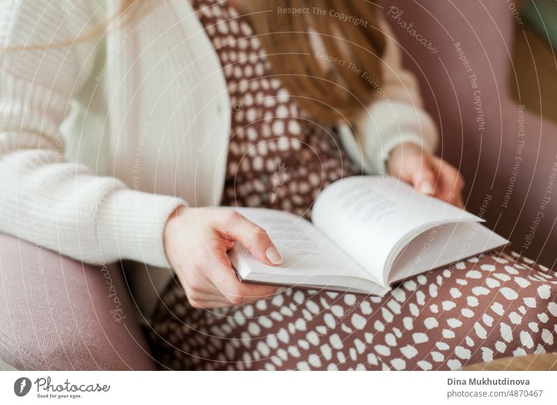 person reading a book at the library. Young woman reading books, studying at the university library, or coworking space, office or at home. Back to school concept.