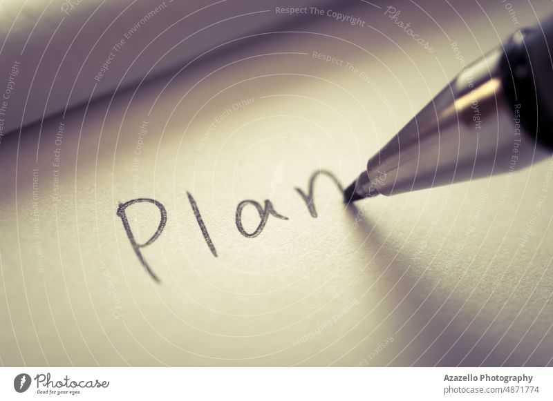 Close up image of writing a word PLAN on a notebook paper. Tasks plan close up macro pen minimalism idea concept conceptual white education planner organizer
