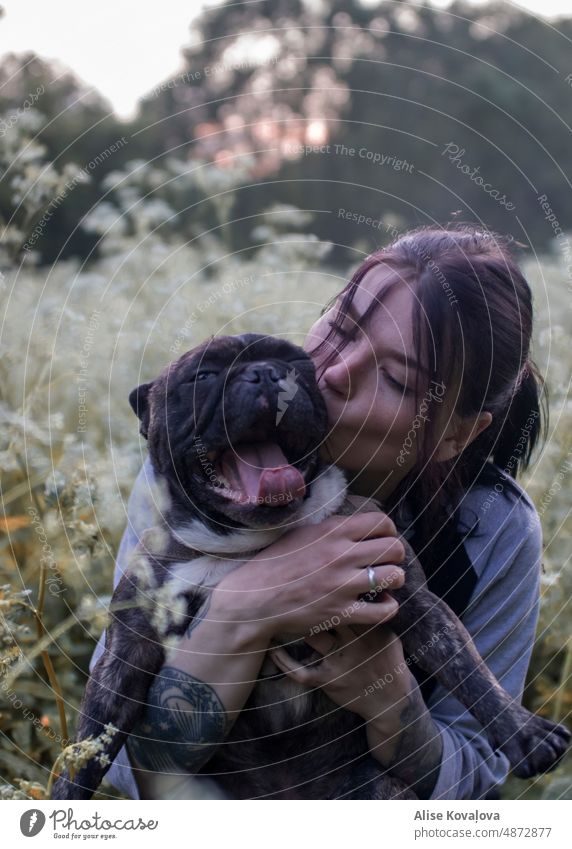 best friends in a meadow, dog yawning french bulldog dog and it’s owner self portrait dark Fur nature after sunset twilight happy kisses