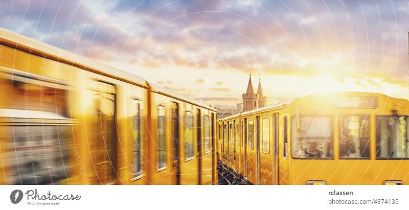 Berliner U-Bahn with Oberbaum Bridge in the background in golden evening light at sunset with dramatic clouds, Berlin Friedrichshain-Kreuzberg berlin germany