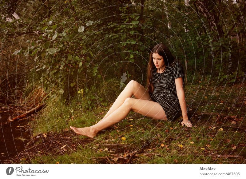 Young woman lying on moss in forest clearing - a Royalty Free Stock Photo  from Photocase