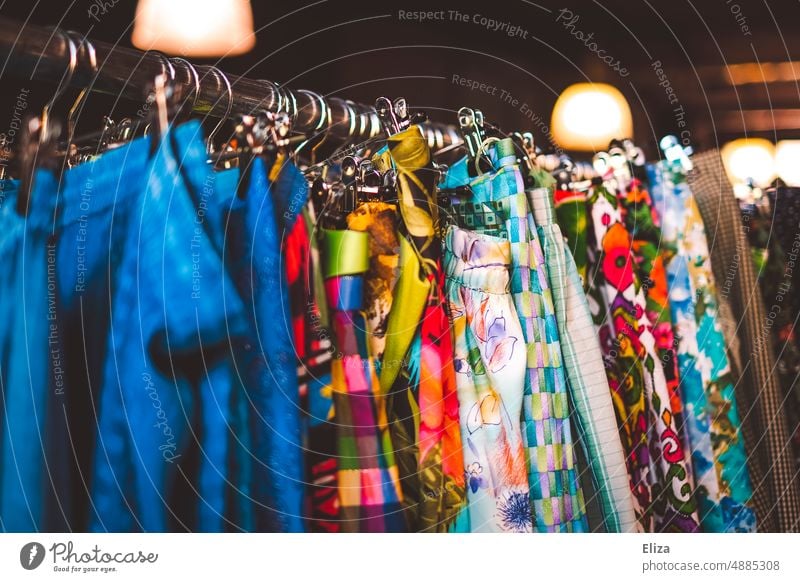 Colorful clothes on a clothes rail in a second hand store or flea