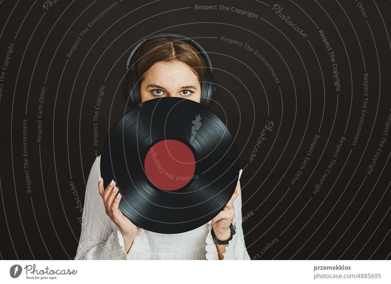 Woman holding vinyl record. Music passion. Listening to music from analog record. Playing music from analog disk. Enjoying music from old collection. Retro and vintage. Stereo audio. Analog sound