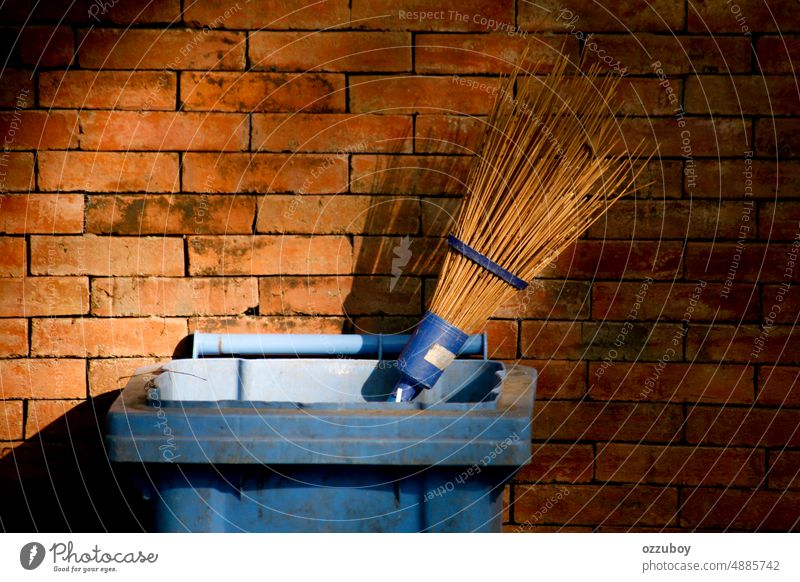 Broom stick in trash cans with brick wall as background dirty broom clean equipment hygiene tool work sweep nature environment outdoor park rubbish broomstick