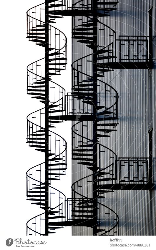 elegant spiral staircase on sober industrial facade Winding staircase Esthetic Curve Silhouette Stairs Facade Emergency exit Steel Line DNA Industrial plant