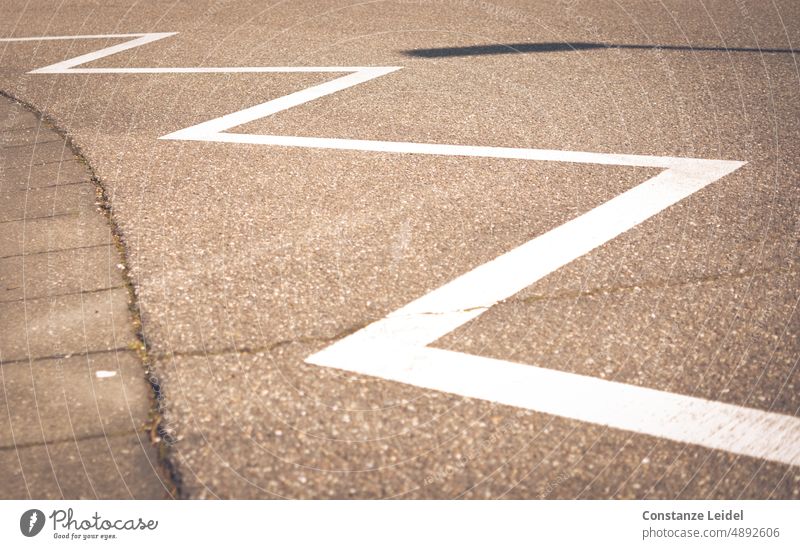 Road marking zigzag stripes with shadow of a lantern in background Safety Line Signs and labeling Lanes & trails Traffic infrastructure Gully Arrangement