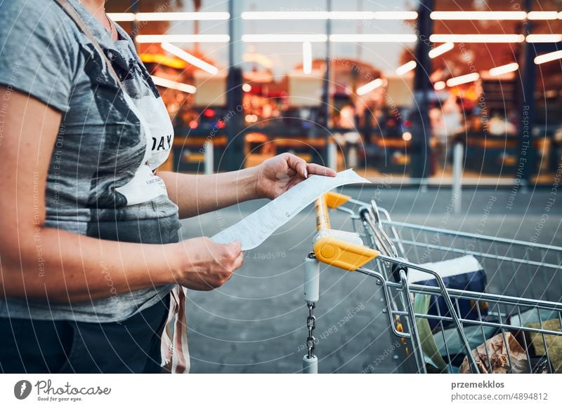 Woman looking at higher prices on receipt after shopping in