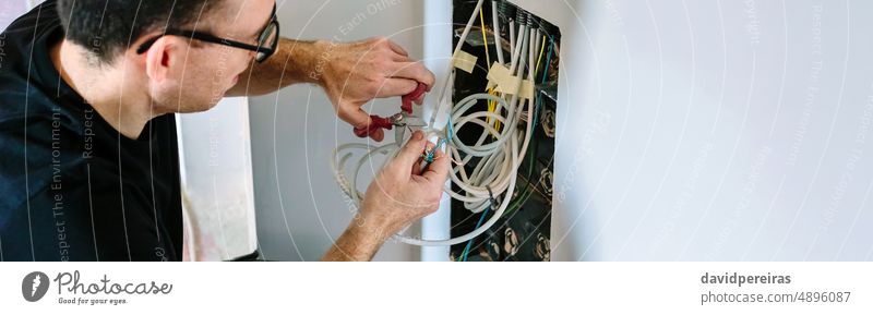 Technician cutting cable to install telecommunication box technician installer installing banner web header panorama panoramic telecommunications box man