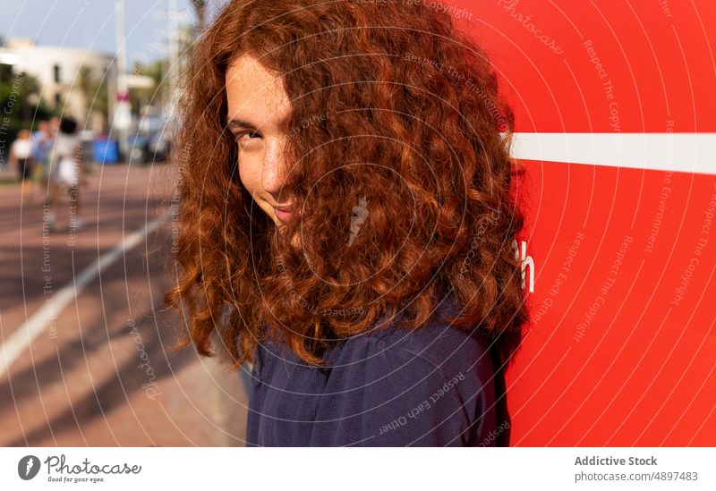 Woman With curly hair Redhead Curly Hair Beautiful Sunlight Wall Lifestyle Arm Raised Leisure Tshirt Attractive Expression Front View Headshot Sunny Confidence