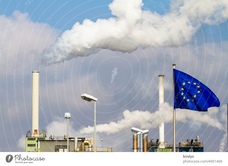 Industrial plant in the European Union. Energy-intensive industry in the energy crisis. Gas shortage, natural gas. Eu flag in front of industrial architecture with smoking chimney, Ukraine war , climate change.