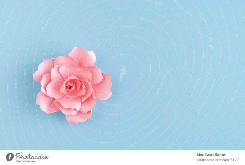 Pink paper flower on blue background. Copy of the space. Flower origami pink copy space top view graphic resources crafts decoration design texture valentine