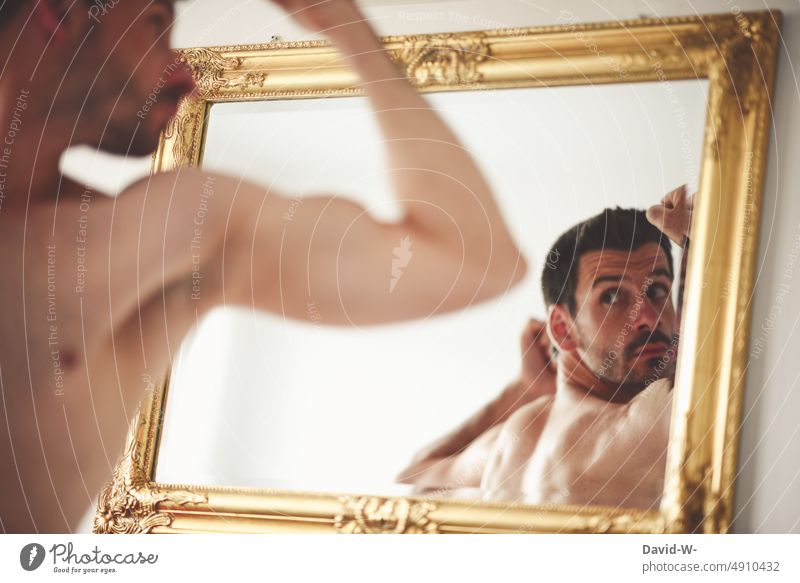 man looking at body in mirror