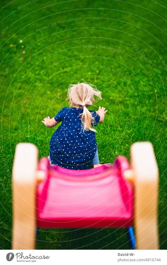 Child on the slide in the garden Slide Skid Playing fun Movement Playground Lawn Girl Joy Infancy Happiness