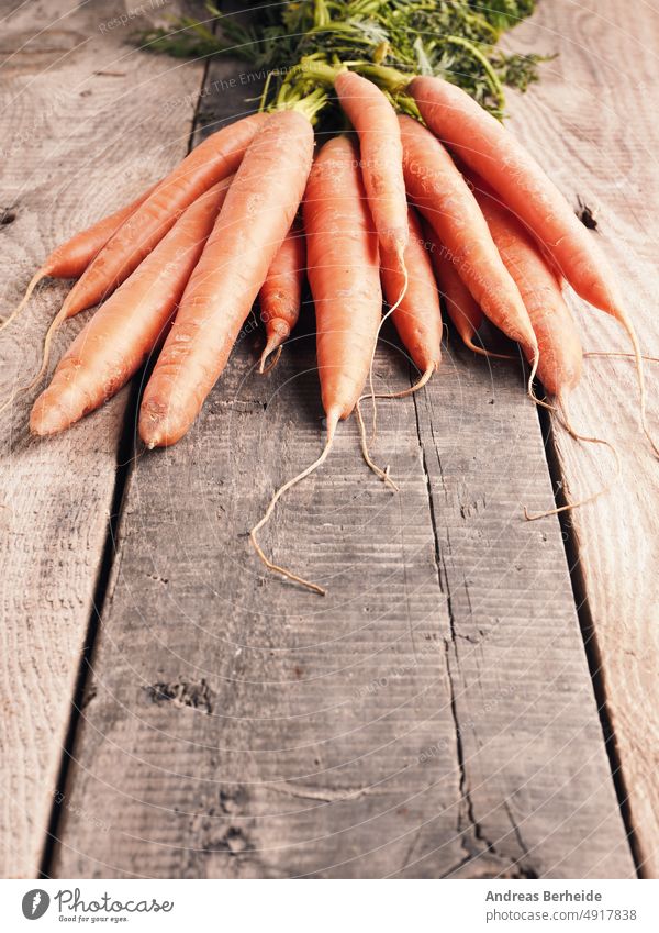 Tasty organic carrots on a rustic wooden table veggie tasty juicy carotene colorful bio natural delicious produce health cultivated farm raw vitamin nutrition