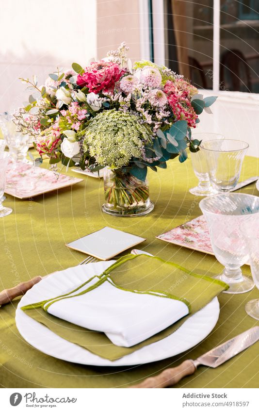 Served table with dishware and flowers table setting plate decor serve style cutlery glassware occasion design creative decoration fork terrace sunlight bouquet