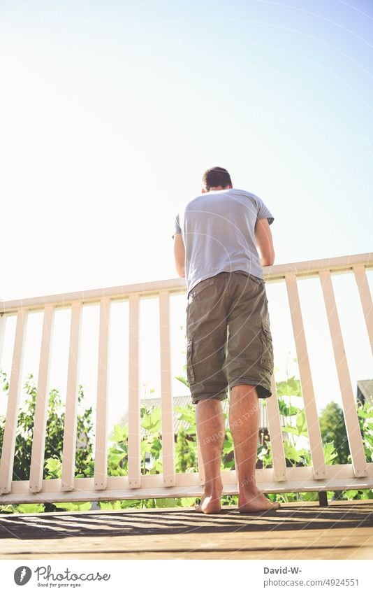 Man standing on a balcony in summer enjoying the nice weather Balcony sunshine Garden House (Residential Structure) Summer Observe Overview Beautiful weather