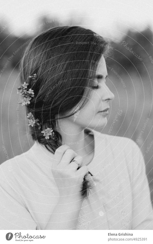 A girl in a beautiful dress stands with her eyes closed. Wildflowers are woven into the hair. field summer closed eyes portrait calmness lifestyle slowdown