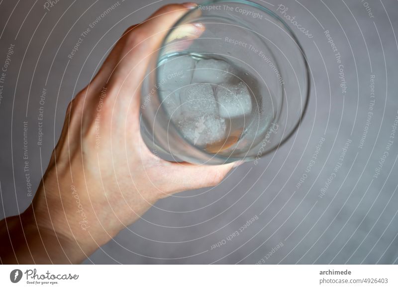 Hand holds a fresh glass of water alcohol close up cocktail cold copy space detail drink drinking freshness hand ice iced in hand still life woman