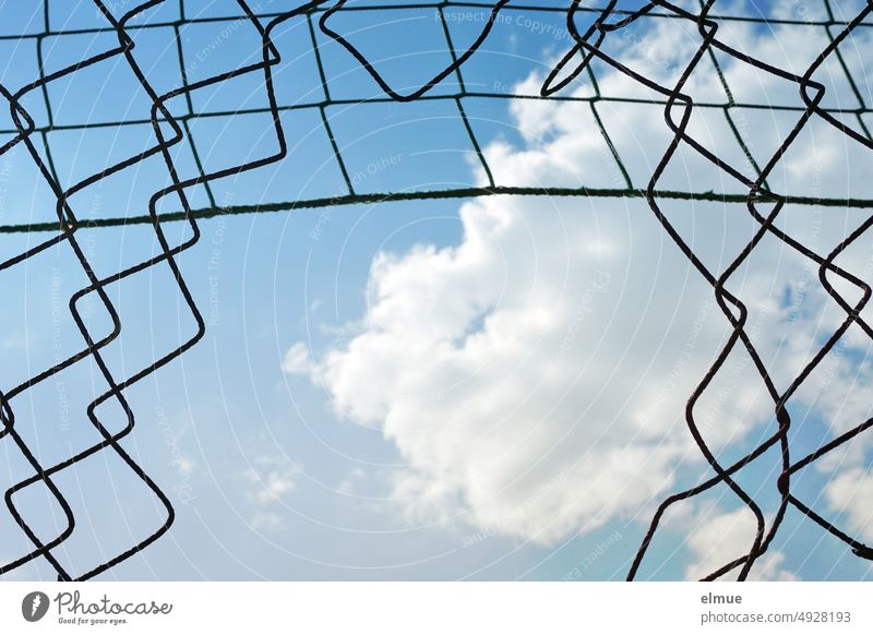 Crime scene I big opening in chain link fence and blue sky with deco cloud / see through / breakthrough Wire netting fence Opening decorative cloud Broken