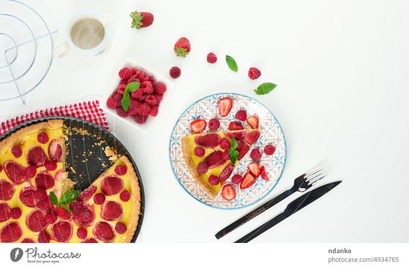 Round quiche with red strawberries and raspberries on a white table pie cake cream food baked fresh round dessert pastry cookery meal homemade slice sweet piece