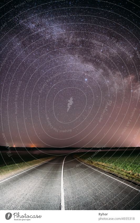 Night Starry Sky Above Country Asphalt Road In Countryside And Green Field. Night View Of Natural Glowing Stars And Milky Way Galaxy asphalt astronomy
