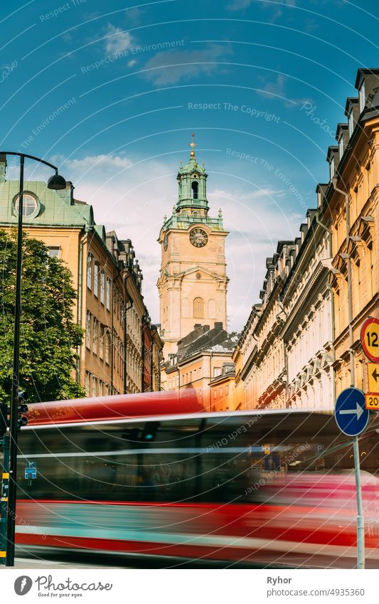 Stockholm, Sweden. Red Bus In Motion Blur Rides Near Old Town With Tower Of Storkyrkan - The Great Church Or Church Of St. Nicholas. Stockholm Cathedral Is The Oldest Church In Gamla Stan