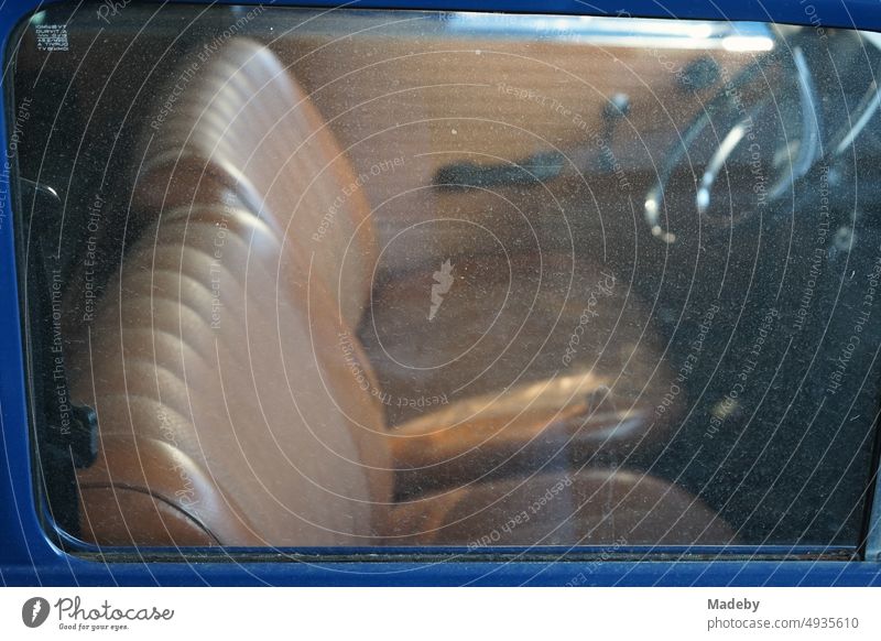 View through the dirty side window on the steering wheel and dashboard of a German rear engine small car of the sixties at the car museum in Lemgo Hörstmar near Detmold in East Westphalia Lippe