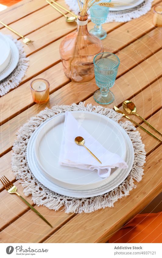 Served banquet table with elegant decorations and plates with cutlery table setting candle vase wheat event crystal style design glassware napkin serve plant