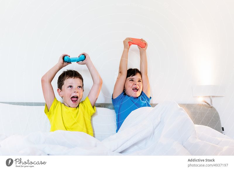 Children playing video game in bed - a Royalty Free Stock Photo