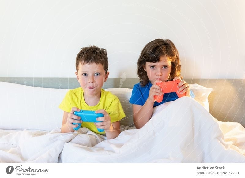 Two brothers playing video games at home. - a Royalty Free Stock Photo from  Photocase