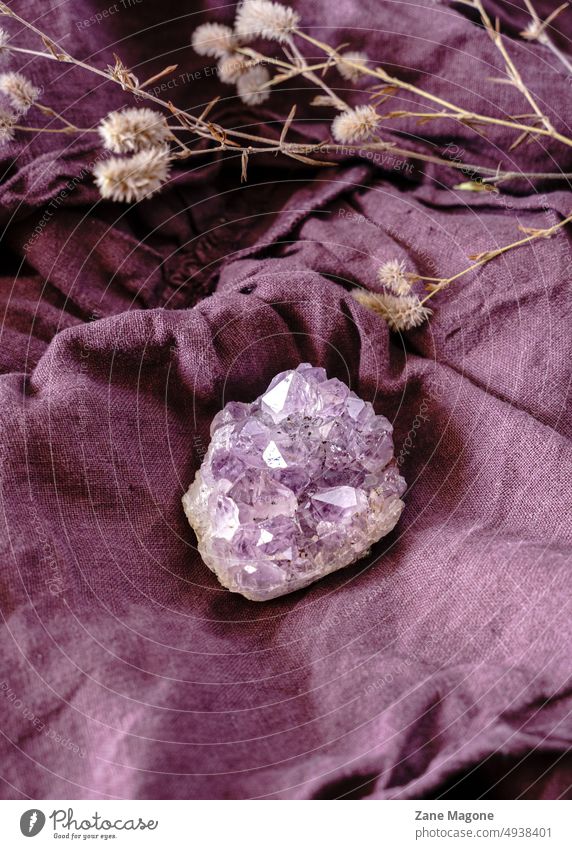 Close up of natural healing crystal (amethyst) flow quartz stone energy alternative medicine complementary medicine flat lay styled violet magical mystical