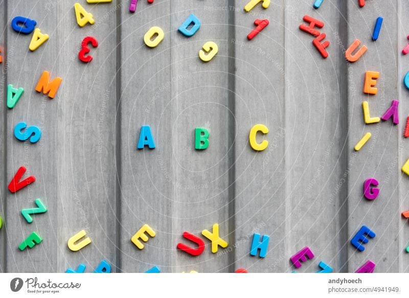 The letters abc on a tin wall in gray surrounded by numbers and letters alphabet back to school beginning blackboard childhood college colourful concept