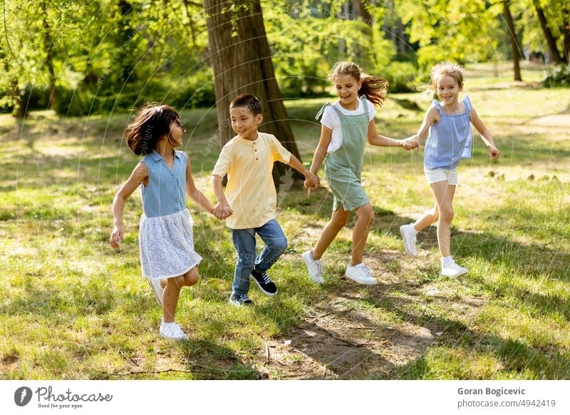 Group of asian and caucasian kids having fun in the park active activity boy bright casual cheerful child childhood children cute descent diverse diversity