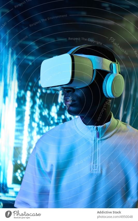 Young African American male watching video in VR goggles man virtual reality concentrate immerse vr experience explore futuristic cyberspace simulate young