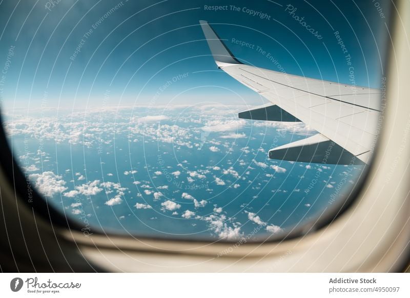 Plane wing in cloudy sky window plane blue sky trip flight aviation fly travel jet transport modern aeroplane airline contemporary airplane altitude motion