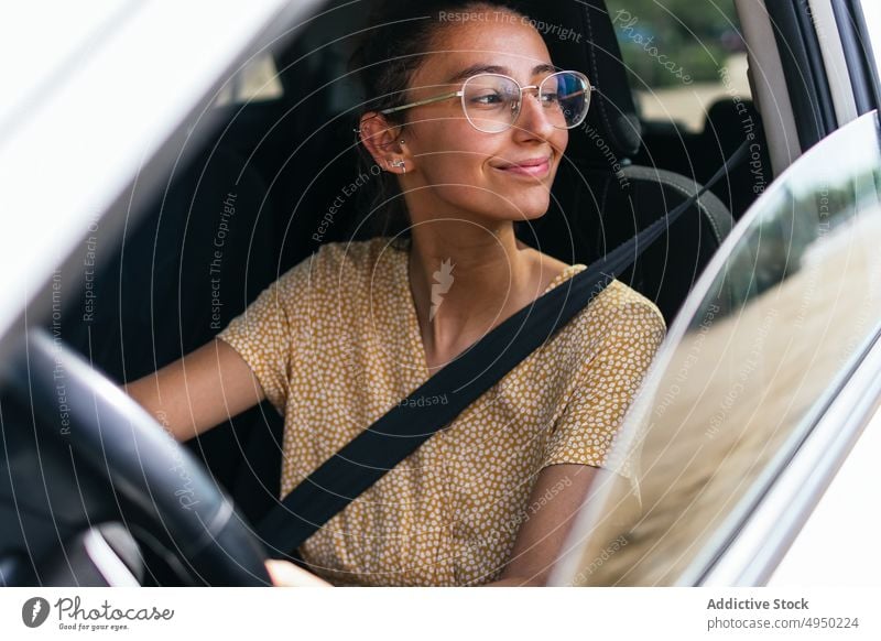 Young woman driving modern car drive road trip steering wheel summer control commute casual female young driver vehicle travel transport daytime automobile