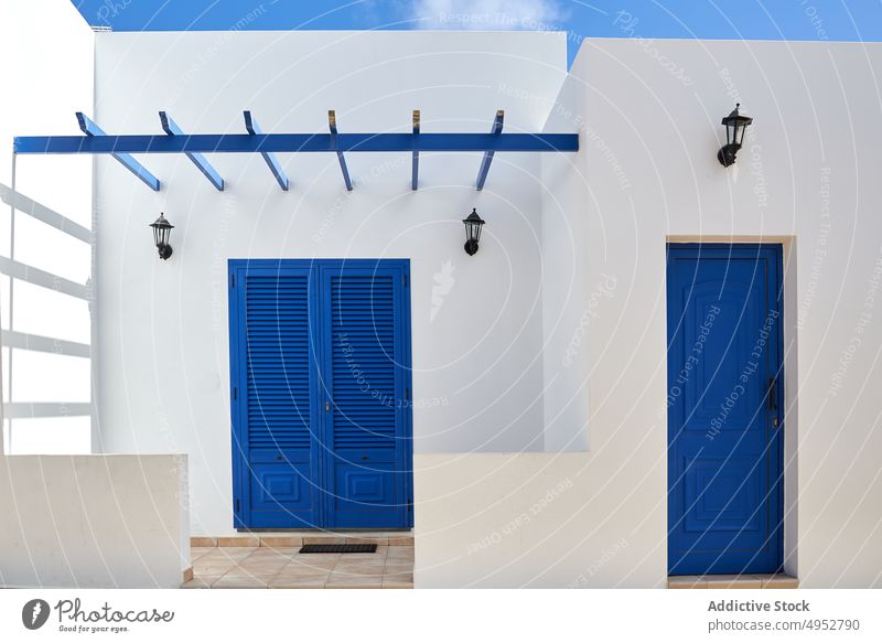 White cottage with bright blue doors on sunny day house exterior white architecture typical residential construction dwell property canary island spain town